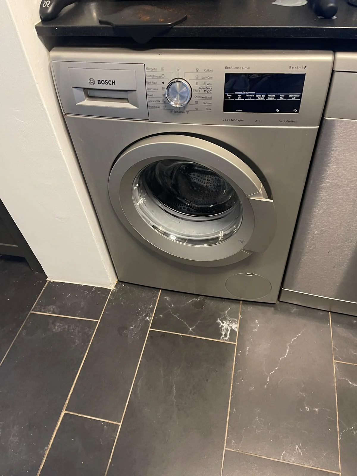 Technician repairing washing machine with specialized tools